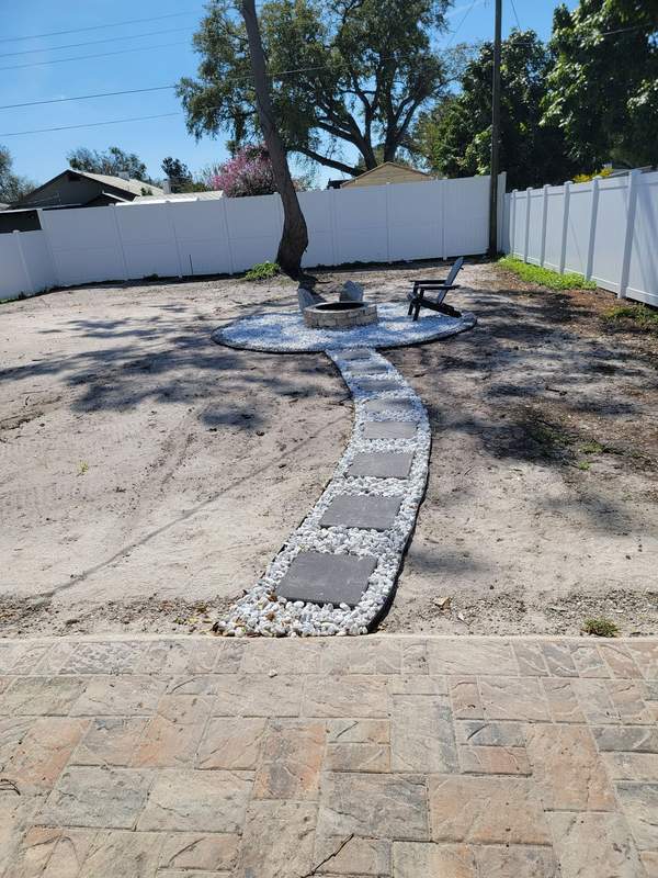 Stone pathway and fire pit area in a backyard